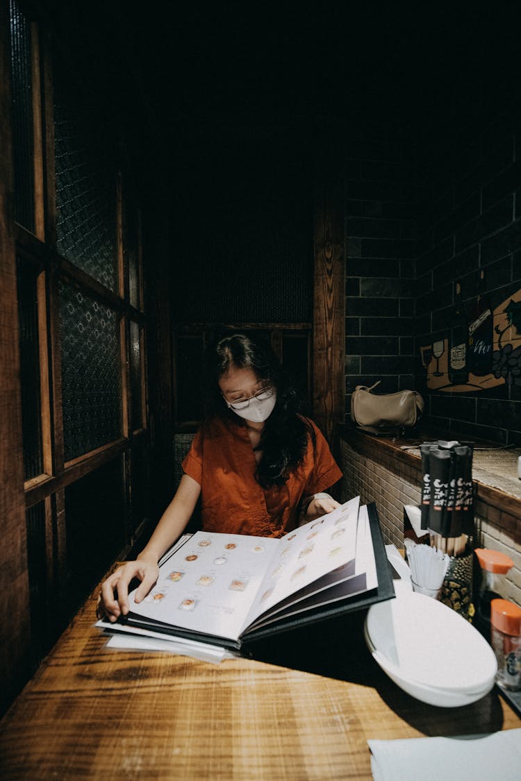 Woman In The Restaurant Looking At The Menu 