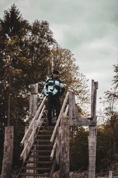 Man in Hoodie Jacket Standing on Rusty Metal Stairs 