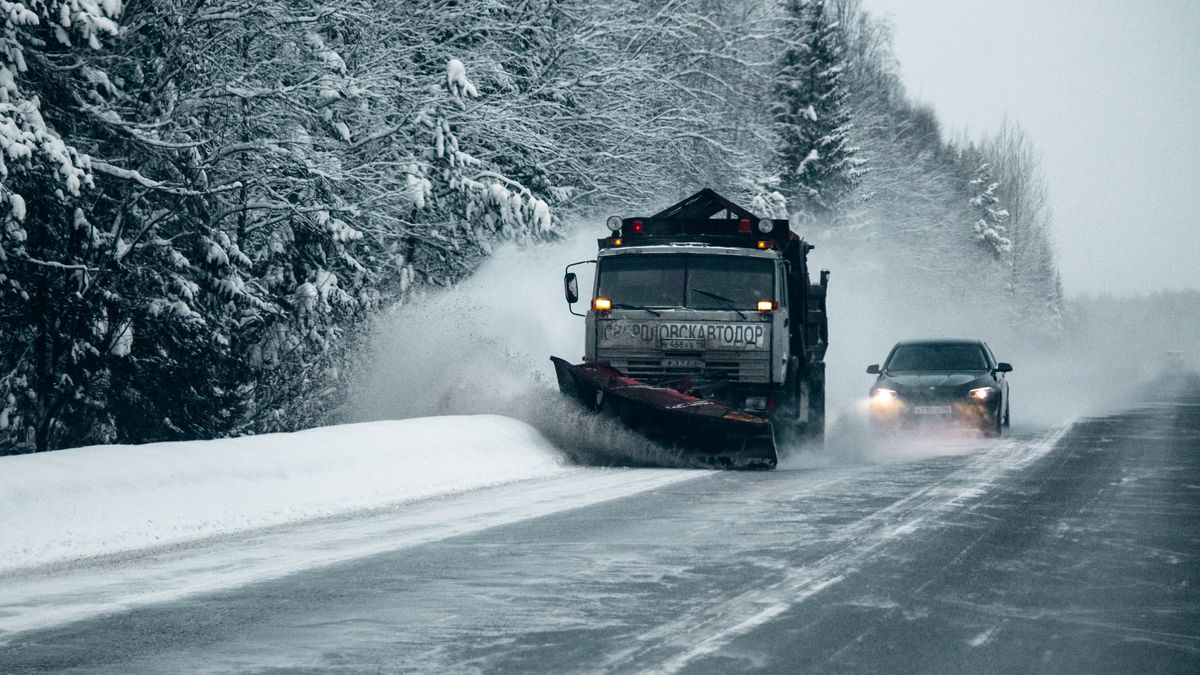 Snow plow clearing a road during a winter storm