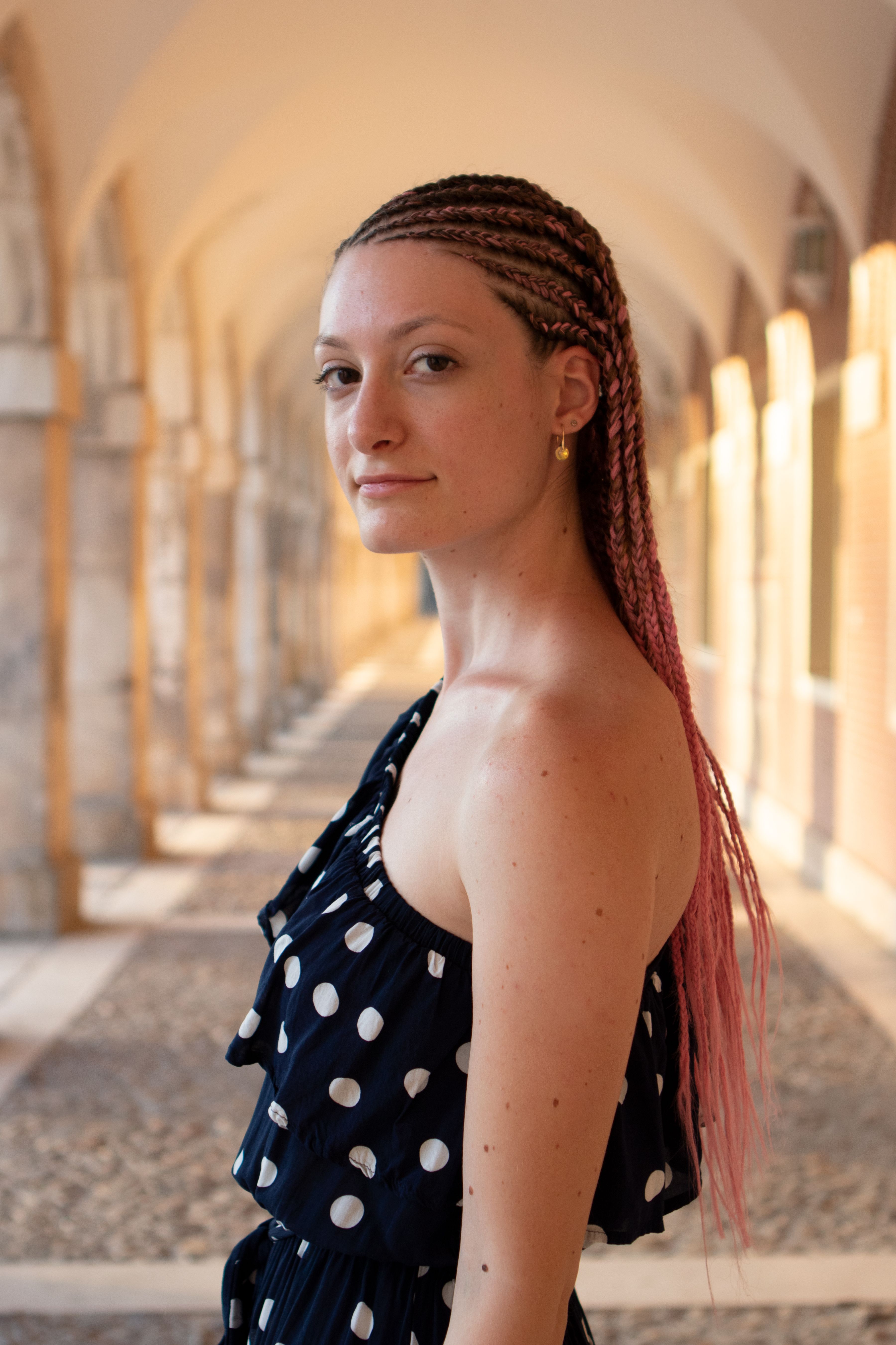 Woman with dreadlocks looking over shoulder in polka dot dress at Aranjuez, Spain.