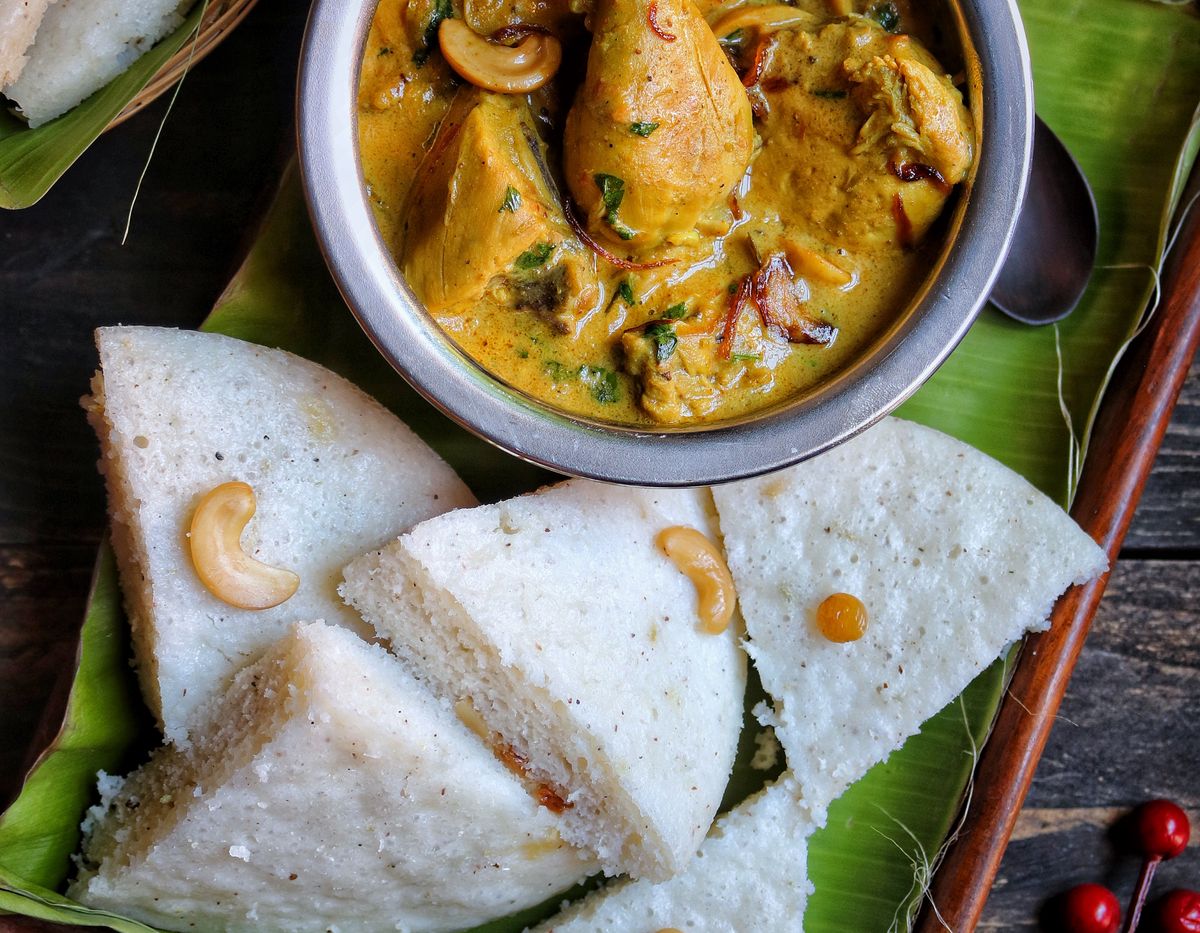 Chicken curry with cashews and soft idli on a banana leaf