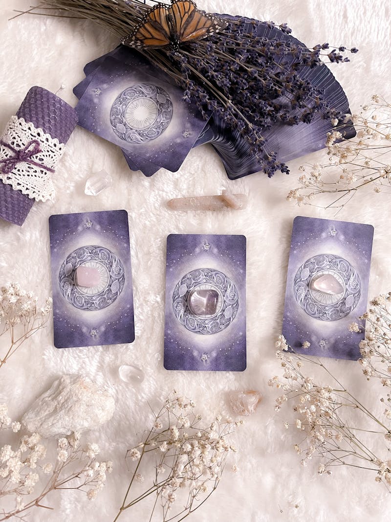 Enchanting tarot card layout with crystals, lavender, and butterfly on soft surface