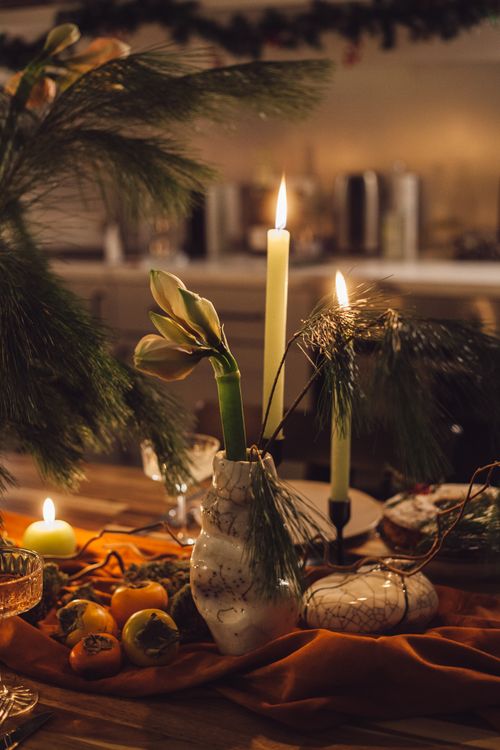Free A warm, festive table setting with candles, conifer branches, and decorations, perfect for Christmas ambiance. Stock Photo