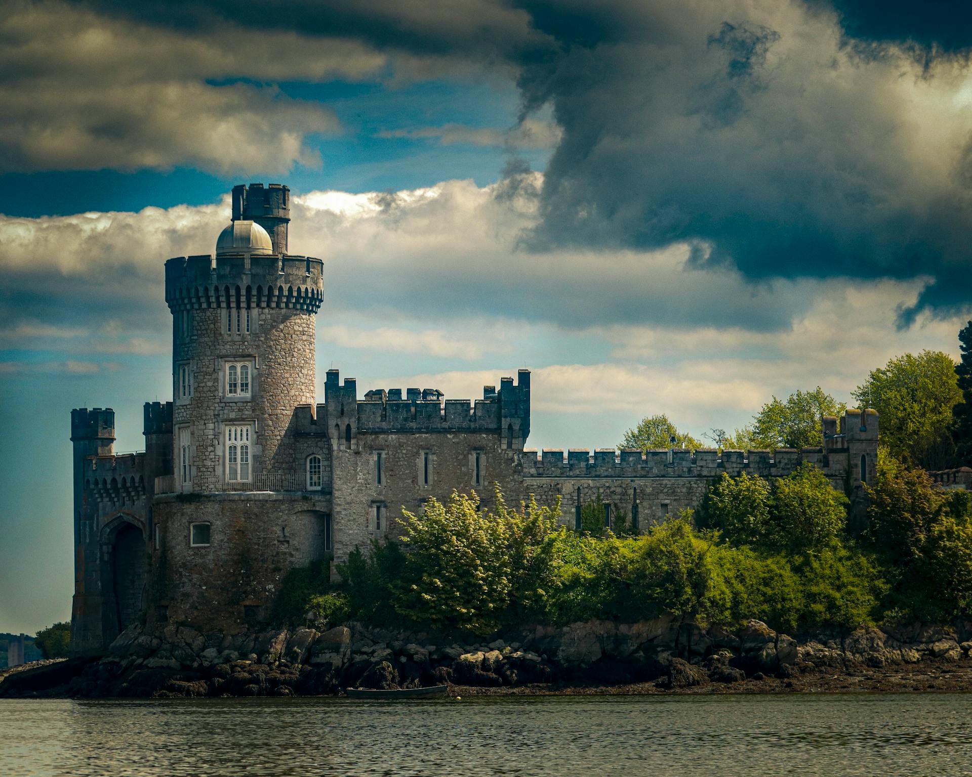 Blackrock Castle with dramatic clouds in Cork, Ireland overlooking the river.