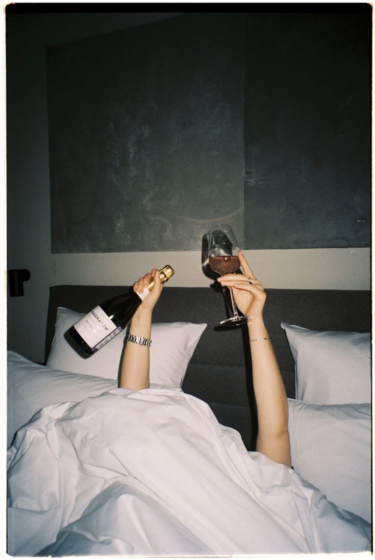 Person Drinking Alcohol In Bed