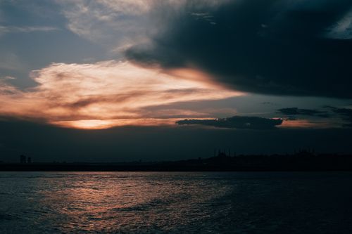 Free Silhouette of Istanbul's iconic skyline against a dramatic sunset sky over the Bosphorus Strait. Stock Photo