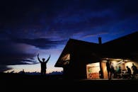 黄昏时分，人们聚集在舒适的小屋里，在室内和户外享受夜晚