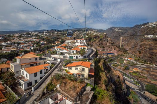 Explore the stunning aerial view of Funchal, Madeira with its iconic cable car and vibrant urban landscape.