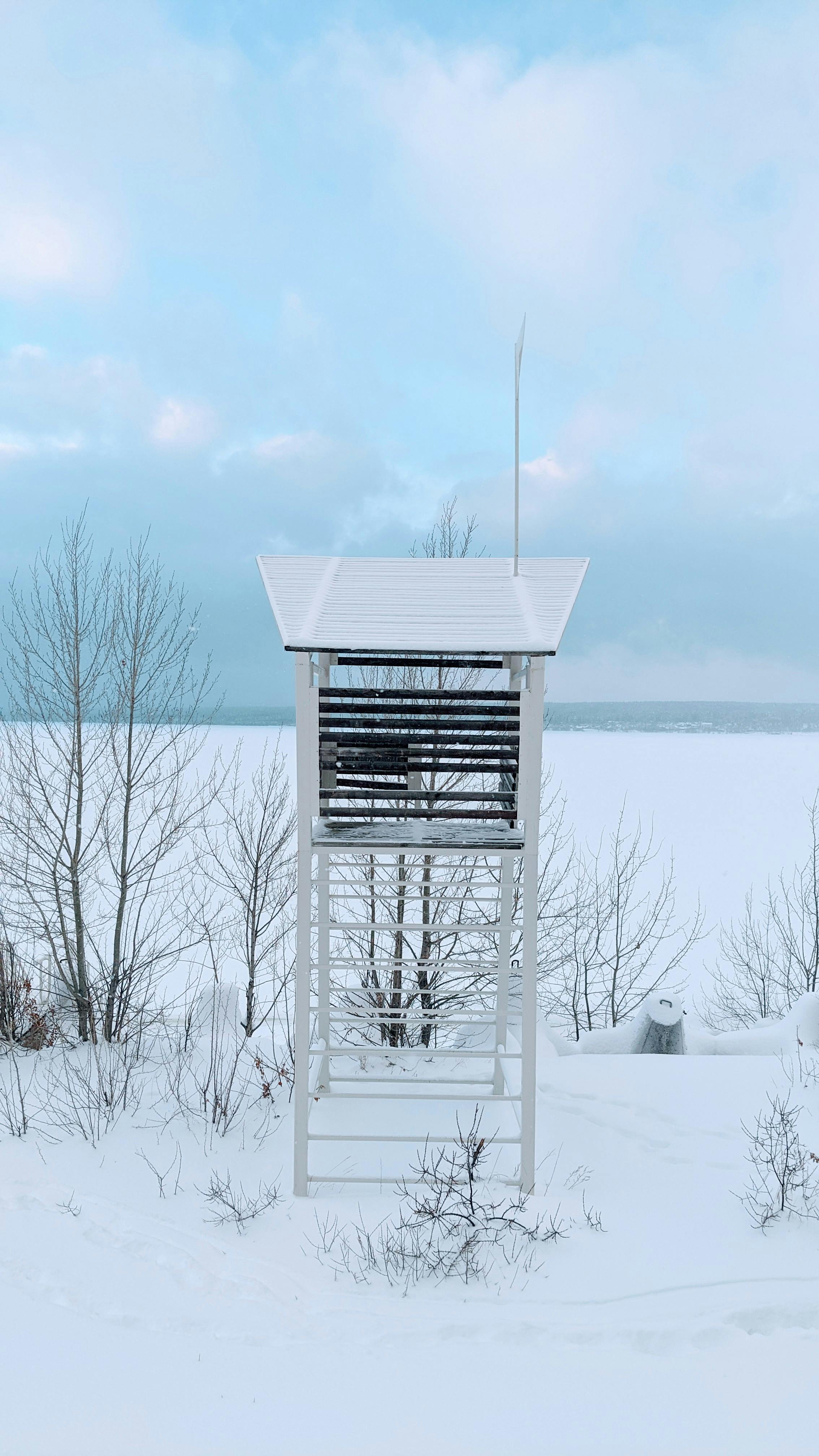 brown wooden shed on snow covered ground