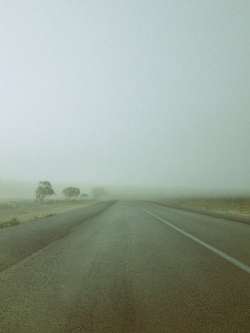 Gray Asphalt Road Under the Foggy Sky