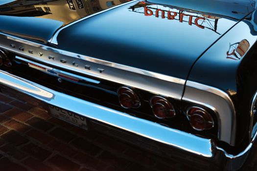 A classic Chevrolet car with mirror-like reflections captures the vintage essence against Seattle's urban backdrop.