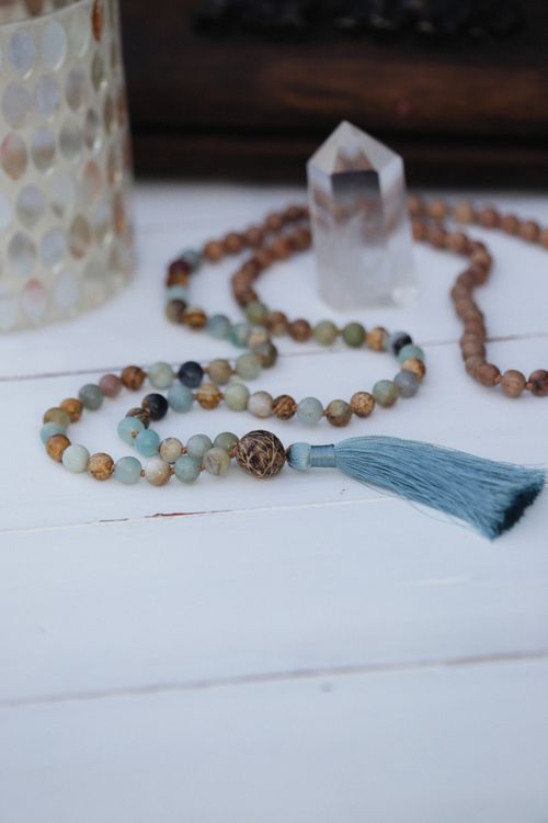 Free Close-up of a beautiful beaded necklace with a blue tassel on a table, perfect for fashion and decor. Stock Photo
