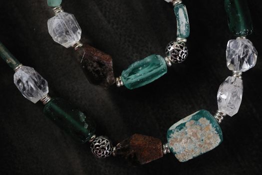 Close-up of a beaded necklace featuring various gemstones and intricate metalwork.