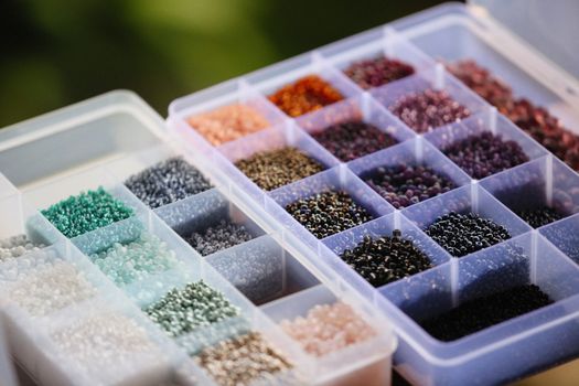 A close-up of a variety of colorful beads arranged in an organizer box, ideal for craft and jewelry making.