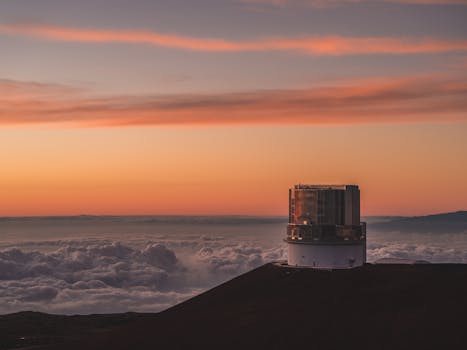 Photo by Qingju Wen A breathtaking view of Mauna Kea Observatory against a vibrant sunset sky in Hawaii.