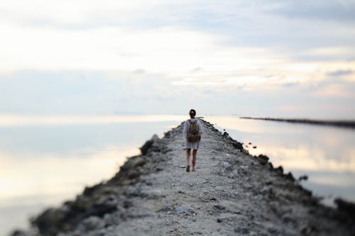 Back View of a Woman Walking on a Breakwater 