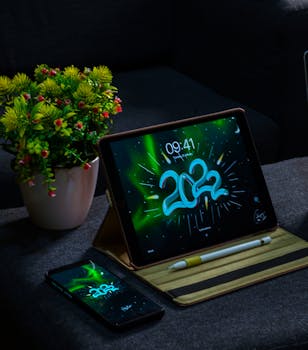 Cozy indoor setting featuring a tablet and smartphone displaying 2022 with potted plant.