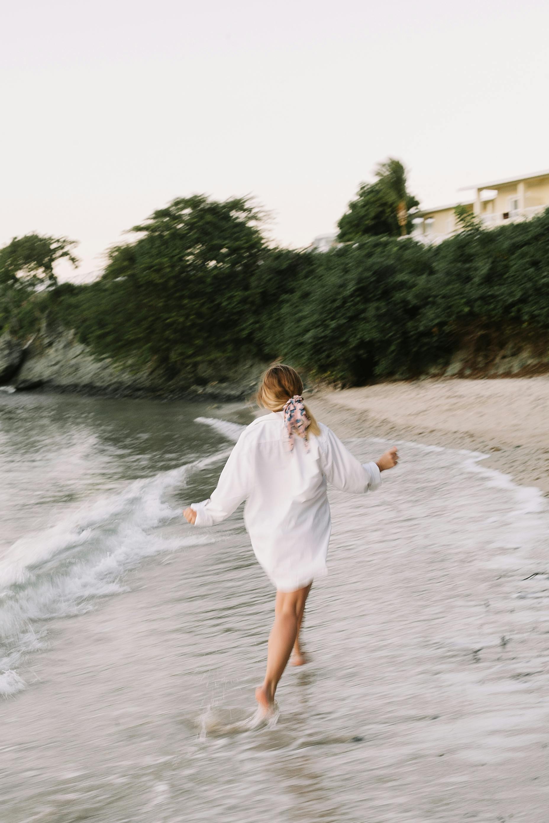 Adult woman walks barefoot on a scenic beach in the Dominican Republic, embracing the natural beauty.