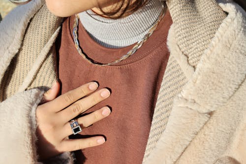 A Close-Up Shot of a Person Wearing a Necklace and a Ring