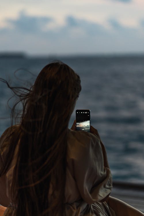 A Woman Taking Photo Using a Smartphone