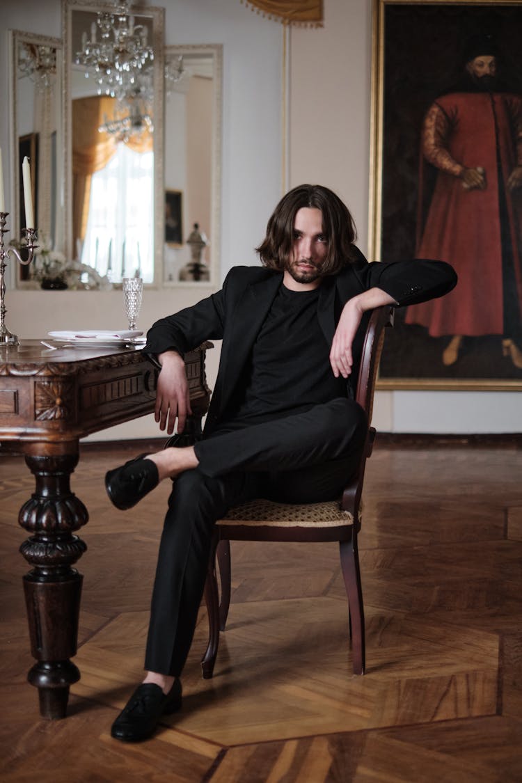 Portrait Of Man In Black Jacket Sitting On Chair