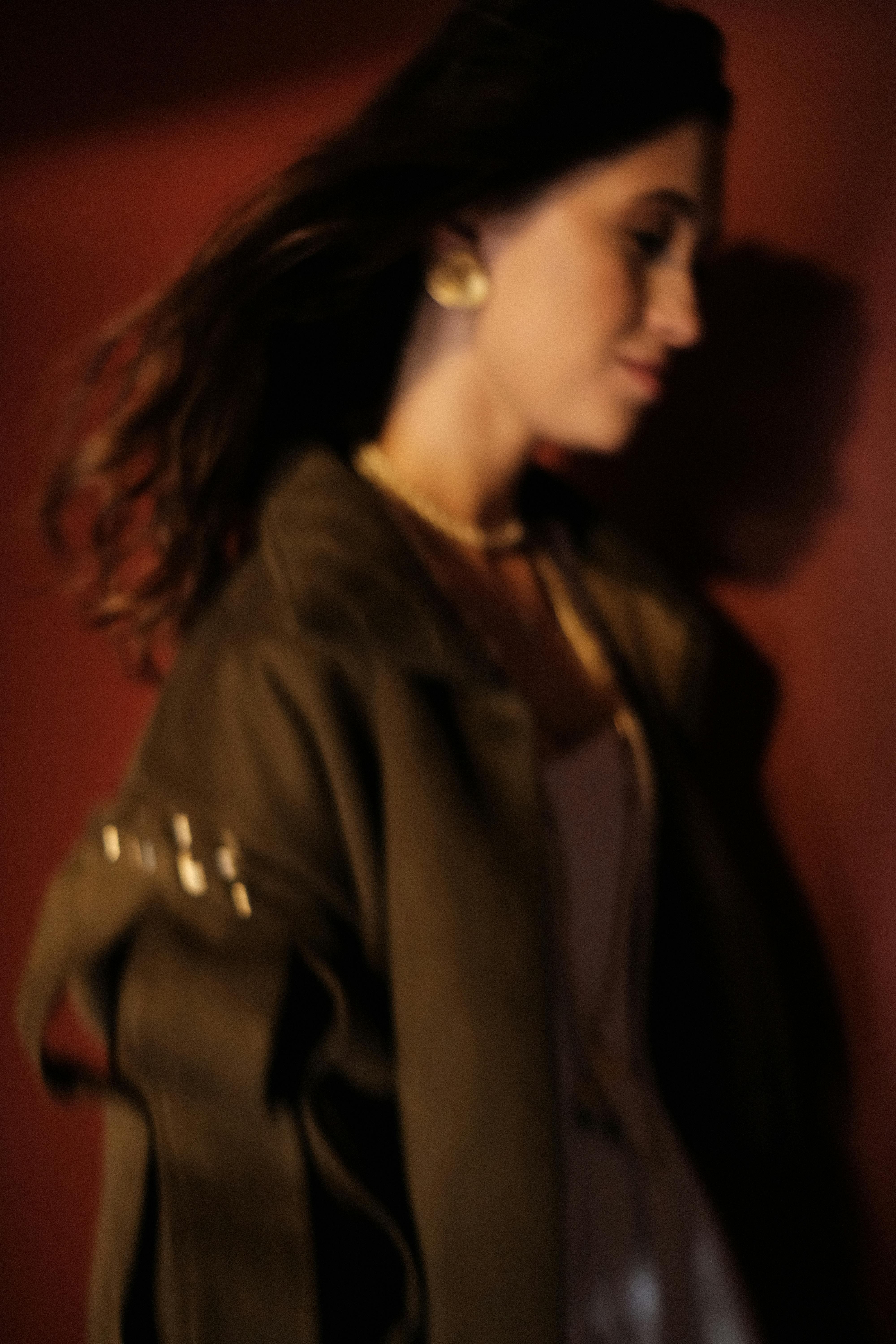 Blurry portrait of a stylish woman in shadow, exuding mystery and elegance.
