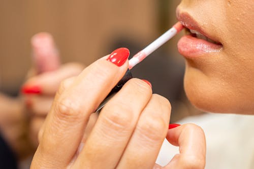 Close Up Photo of a Person Applying Lipstick