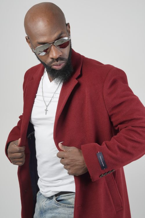 Free Fashionable man with a red blazer and sunglasses posing confidently against a white background. Stock Photo
