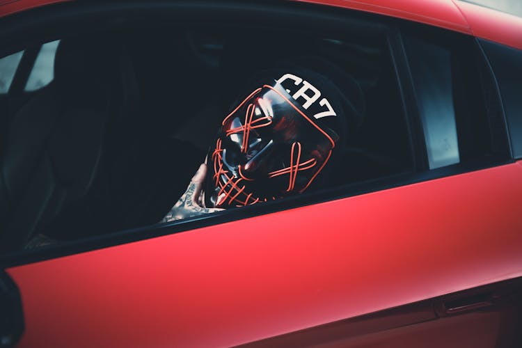 Person In Halloween Mask Sitting On Car