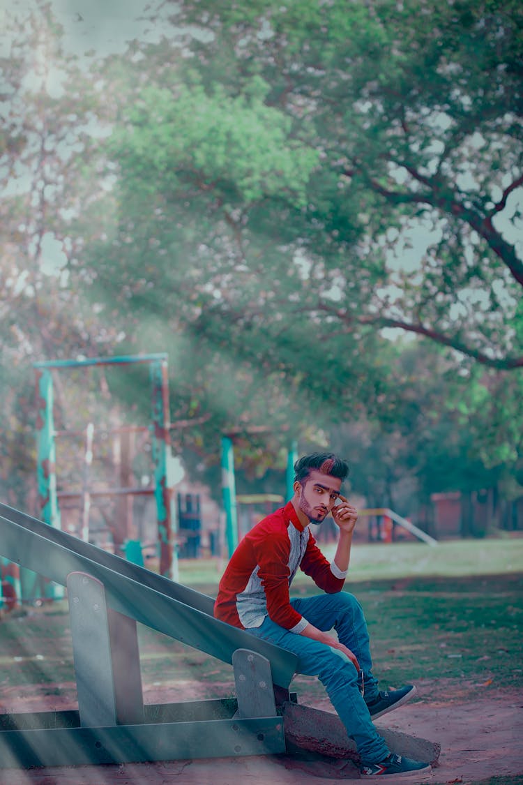 Man Wearing Red Long-sleeved Shirt Sitting On Slide