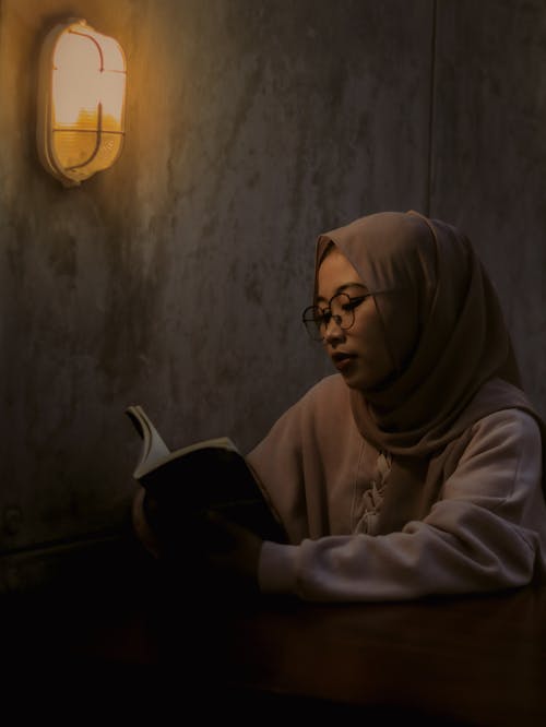 Woman in Brown Hijab Reading a Book