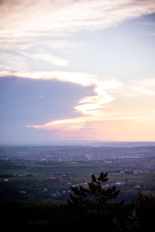 Free Serene aerial shot showcasing a lush town with vibrant sky at sunset, perfect for landscapes. Stock Photo