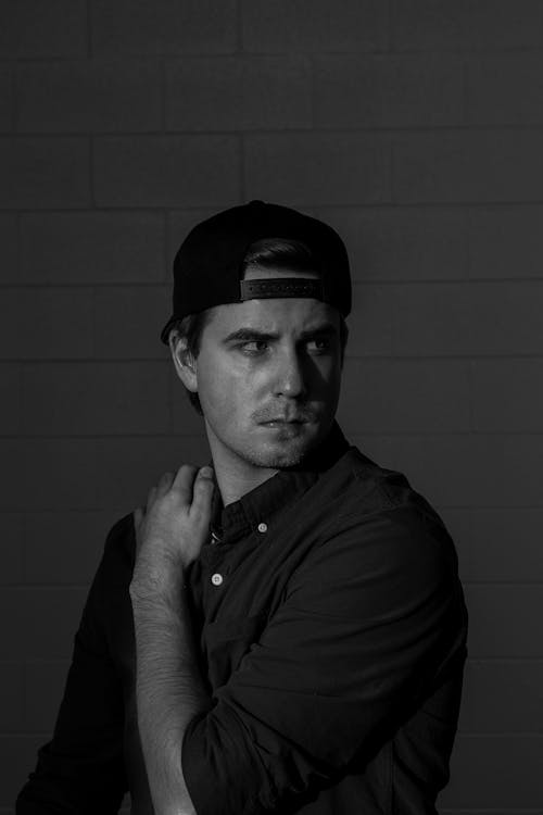 Black and White Photo of a Man Wearing Cap