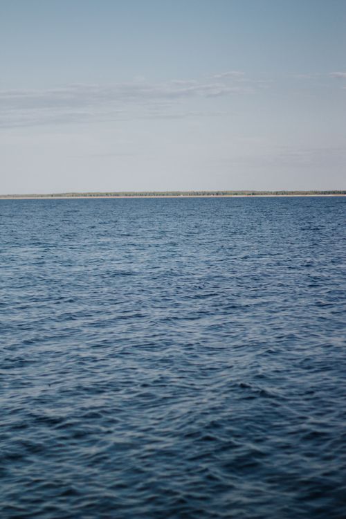 Free A serene ocean scene with calm waters and an open horizon under a clear blue sky, perfect for peaceful settings. Stock Photo