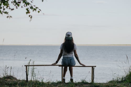 Back View of a Woman Sitting on a Bench and Looking at Seascape