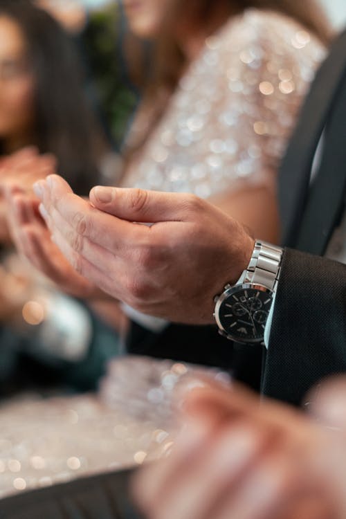 Closeup of a Woman in a Silver Glittering Dress and Man Praying