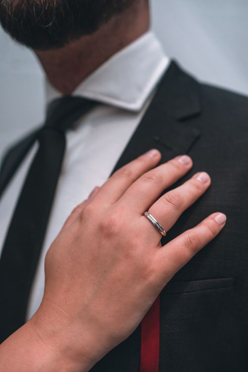 Free Elegant close-up of wedding day moments capturing a ring on a groom's suit. Stock Photo
