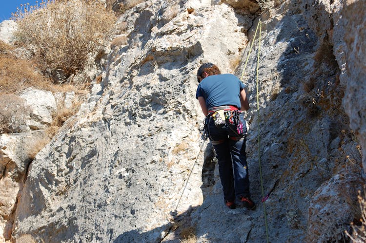 Low-Angle Shot Of A Woman Climbing A Rocky Mountain