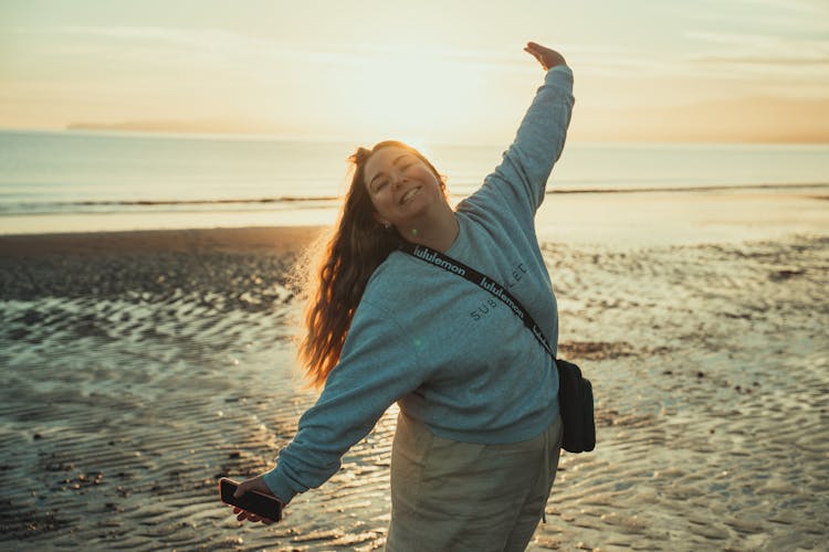 Woman In Gray Sweatshirt Standing On Beach