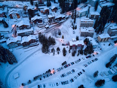 Aerial photo of snow-covered Arosa, a charming village in Switzerland during winter dusk.