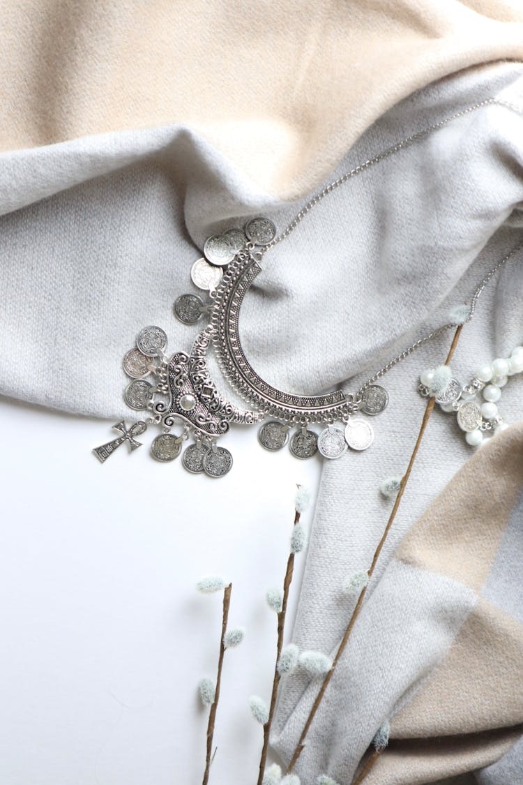 Silver Studded Necklace On White Textile