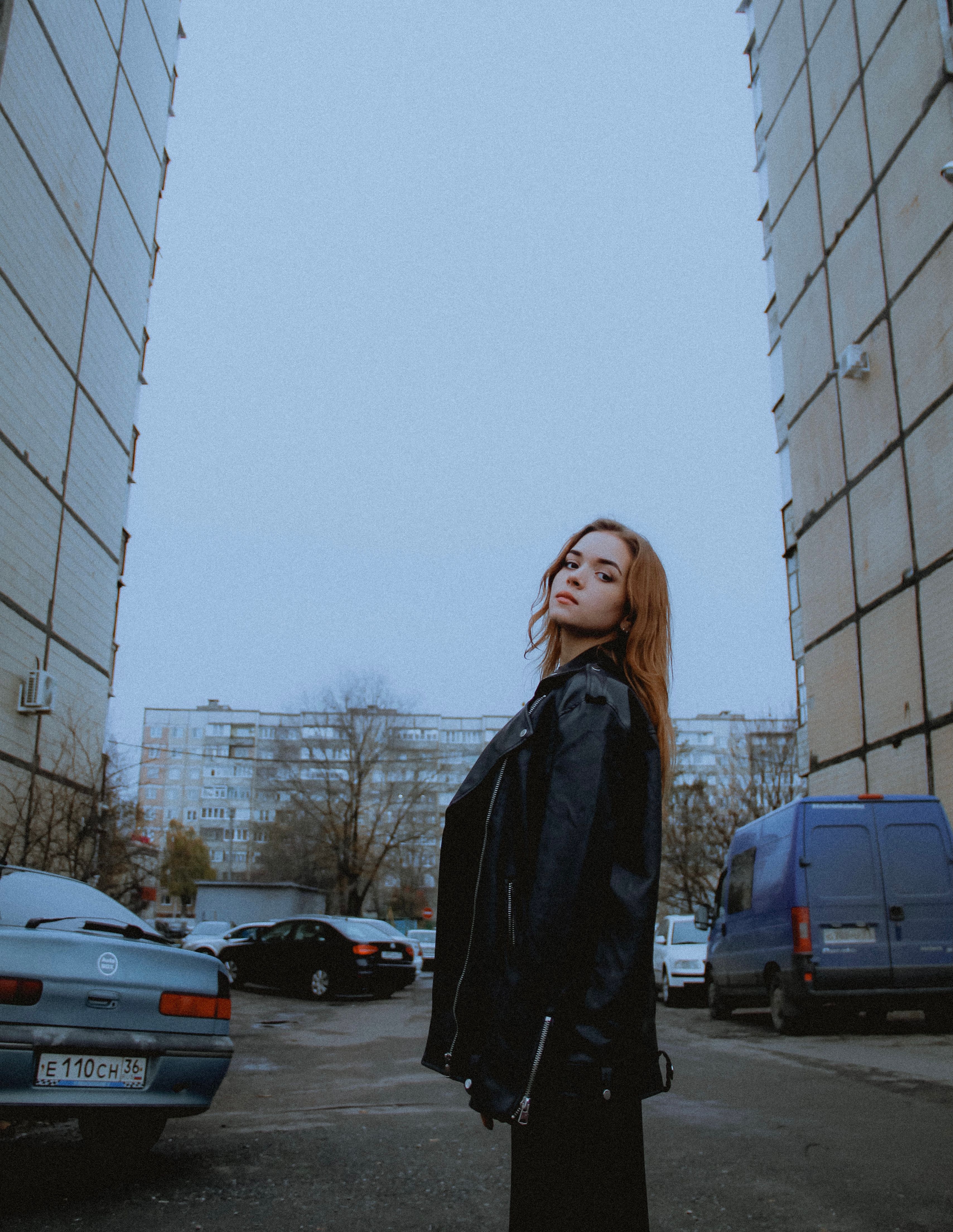 Woman in Black Leather Jacket Standing Near Buildings · Free Stock Photo