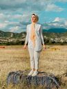 Woman in White Blazer Standing on Brown Grass Field