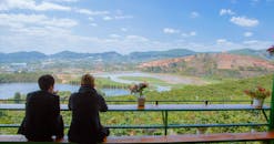 两个人在宁静的环境中欣赏着湖泊和山脉的美景