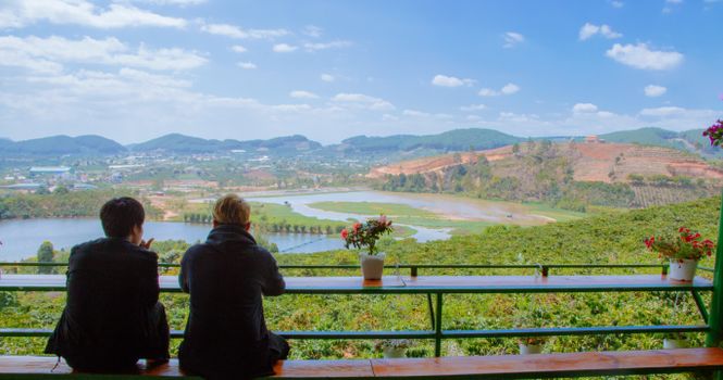 两个人在宁静的环境中欣赏着湖泊和山脉的美景