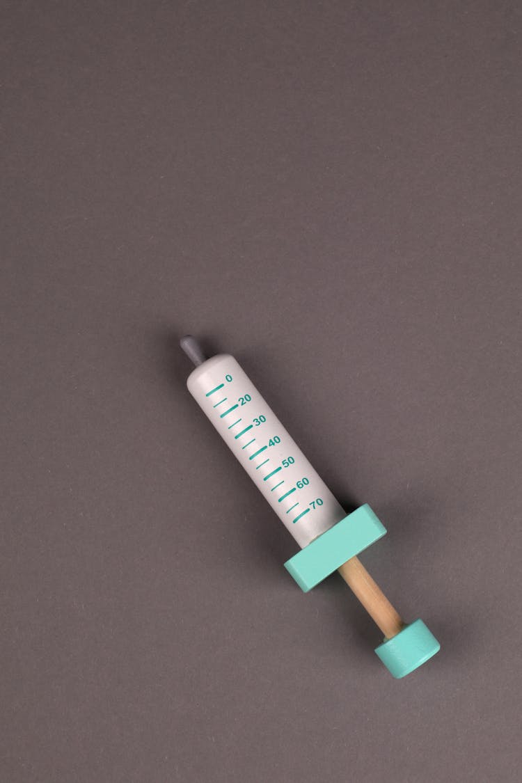 Children Toy Syringe On Grey Background