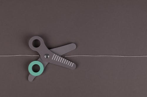 Gray and Green Scissors on Gray Surface