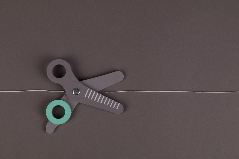 A minimalist flat lay of scissors on a gray background with a string, creating a modern composition.