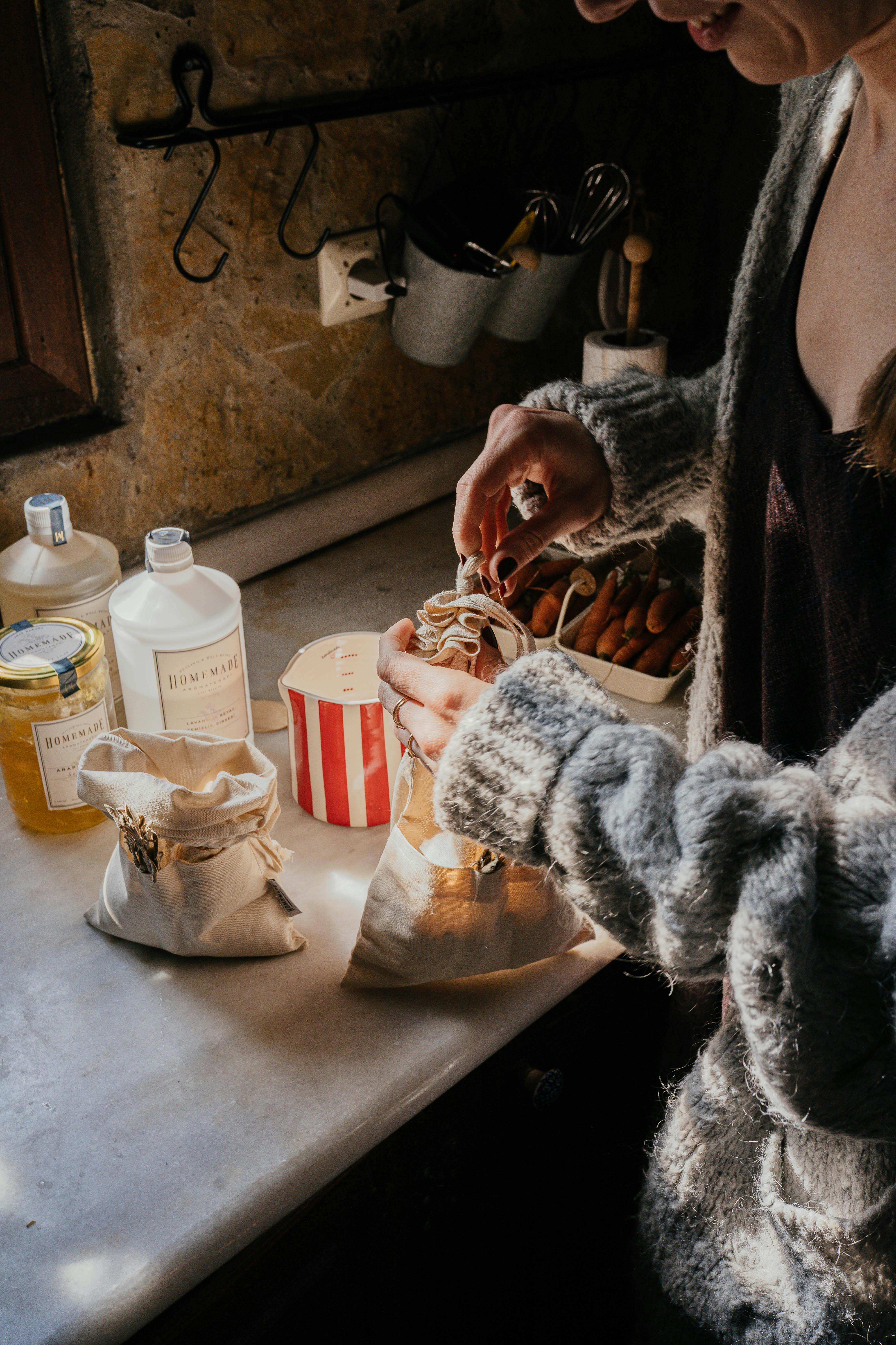 A woman preparing food in a rustic kitchen setup with ingredients and warm lighting.