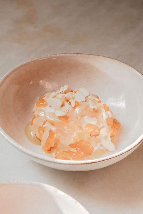 Free A delicate dessert topped with almond slices in a ceramic bowl, ideal for food photography. Stock Photo